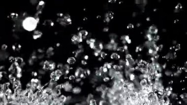 Su damlacıkları siyah arka planda yükselir ve düşer. 1000 fps 'de yüksek hızlı bir kamerayla çekildi. Yüksek kaliteli FullHD görüntüler