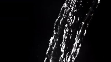 Siyah arka planda su akışı. 1000 fps 'de yüksek hızlı bir kamerayla çekildi. Yüksek kaliteli FullHD görüntüler