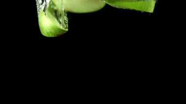 Yeşil elma parçaları suyun altına düşer. 1000 fps 'de yüksek hızlı bir kamerayla çekildi. Yüksek kaliteli FullHD görüntüler