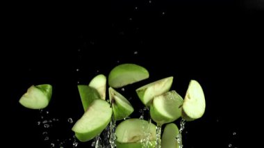 Yeşil elma dilimleri siyah stüdyoya çarpar, yüksek kontrastlı damlacıklar enerjik kavisler halinde dağılır, parlak yeşil film 1000 fps hızla yüksek hızlı kamera ile çekilir. Yüksek kaliteli FullHD görüntüler.