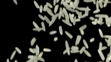 Siyah arka planda beyaz pirinç uçuyor. 1000 fps 'de yüksek hızlı bir kamerayla çekildi. Yüksek kaliteli FullHD görüntüler
