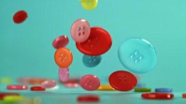 Masaya çok renkli dikiş düğmeleri düşer. 1000 fps 'de yüksek hızlı bir kamerayla çekildi. Yüksek kaliteli FullHD görüntüler