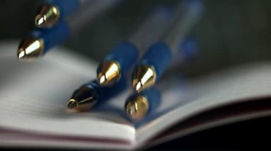 Kalemler açık bir okul defterine düşer. 1000 fps 'de yüksek hızlı bir kamerayla çekildi. Yüksek kaliteli FullHD görüntüler