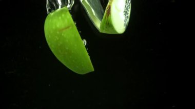Yeşil elma parçaları suyun altına düşer. 1000 fps 'de yüksek hızlı bir kamerayla çekildi. Yüksek kaliteli FullHD görüntüler