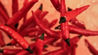 Chili biberleri yukarı uçar ve arka planda hafif bir zemine düşer. 1000 fps 'de yüksek hızlı bir kamerayla çekildi. Yüksek kaliteli FullHD görüntüler