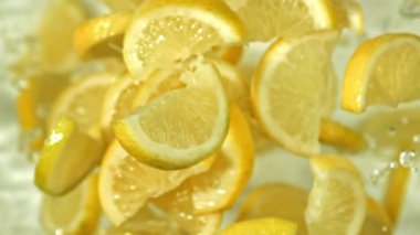 Limon dilimleri arka planda uçar. 1000 fps 'de yüksek hızlı bir kamerayla çekildi. Yüksek kaliteli FullHD görüntüler