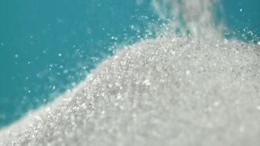 Mavi arka planda bir yığın şeker düşüyor. 1000 fps 'de yüksek hızlı bir kamerayla çekildi. Yüksek kaliteli FullHD görüntüler