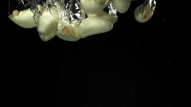 Sarımsak karanfilleri suyun altına düşer. 1000 fps 'de yüksek hızlı bir kamerayla çekildi. Yüksek kaliteli FullHD görüntüler