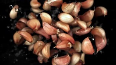 Sarımsak karanfilleri uçar ve siyah arka plana düşer. 1000 fps 'de yüksek hızlı bir kamerayla çekildi. Yüksek kaliteli FullHD görüntüler