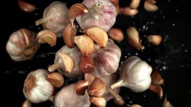 Sarımsak yukarı uçar ve siyah bir zemine düşer. 1000 fps 'de yüksek hızlı bir kamerayla çekildi. Yüksek kaliteli FullHD görüntüler