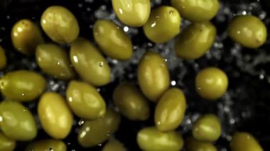 Siyah arka planda uçuşan zeytinler. 1000 fps 'de yüksek hızlı bir kamerayla çekildi. Yüksek kaliteli FullHD görüntüler