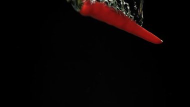 Kırmızı biber suyun altına düşer. 1000 fps 'de yüksek hızlı bir kamerayla çekildi. Yüksek kaliteli FullHD görüntüler