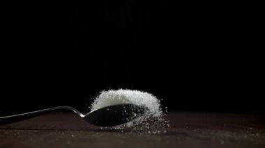 Bir kaşık dolusu şeker masaya düşer. 1000 fps 'de yüksek hızlı bir kamerayla çekildi. Yüksek kaliteli FullHD görüntüler