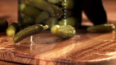 Salatalık turşusu kesme tahtasına düşer. 1000 fps 'de yüksek hızlı bir kamerayla çekildi. Yüksek kaliteli FullHD görüntüler