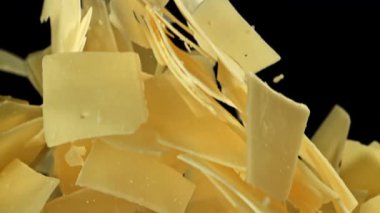Parmesan peynirleri siyah arka planda yukarı doğru uçar. 1000 fps 'de yüksek hızlı bir kamerayla çekildi. Yüksek kaliteli FullHD görüntüler