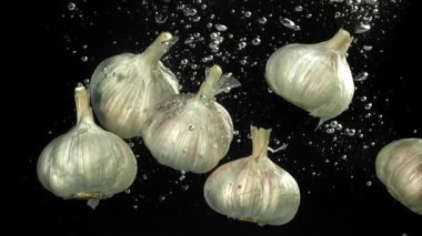 Taze sarımsak başları suyun altına düşer. 1000 fps 'de yüksek hızlı bir kamerayla çekildi. Yüksek kaliteli FullHD görüntüler