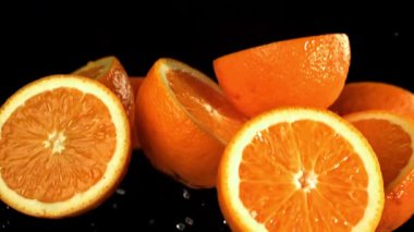 Siyah arka planda uçuşan portakal dilimleri. 1000 fps 'de yüksek hızlı bir kamerayla çekildi. Yüksek kaliteli FullHD görüntüler