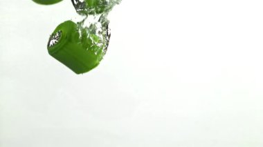 Dilimlenmiş pırasa yeşil arka planda suyun altına düşüyor. 1000 fps 'de yüksek hızlı bir kamerayla çekildi. Yüksek kaliteli FullHD görüntüler