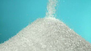 Mavi arka planda bir yığın şeker düşüyor. 1000 fps 'de yüksek hızlı bir kamerayla çekildi. Yüksek kaliteli FullHD görüntüler