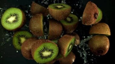 Kesilmiş kivi parçaları siyah arka planda uçar. 1000 fps 'de yüksek hızlı bir kamerayla çekildi. Yüksek kaliteli FullHD görüntüler