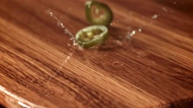 Terbiye edilmiş jalapenolar tahtaya düşer. 1000 fps 'de yüksek hızlı bir kamerayla çekildi. Yüksek kaliteli FullHD görüntüler