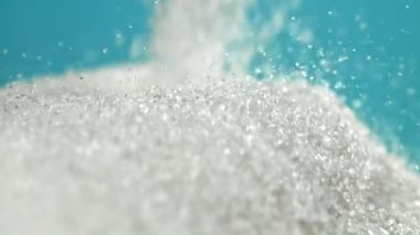 Mavi arka planda bir yığın şeker düşüyor. 1000 fps 'de yüksek hızlı bir kamerayla çekildi. Yüksek kaliteli FullHD görüntüler