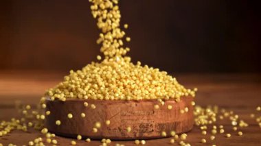 Millet Groats ahşap bir kaseye düşer. 1000 fps 'de yüksek hızlı bir kamerayla çekildi. Yüksek kaliteli FullHD görüntüler