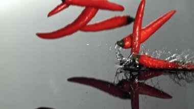Şili biberleri ıslak bir yüzeye düşer. 1000 fps 'de yüksek hızlı bir kamerayla çekildi. Yüksek kaliteli FullHD görüntüler