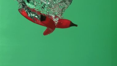 Kırmızı biber suyun altına düşer. 1000 fps 'de yüksek hızlı bir kamerayla çekildi. Yüksek kaliteli FullHD görüntüler