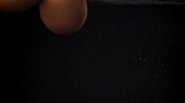 Siyah arka planda suyun altına düşen yumurtalar. 1000 fps 'de yüksek hızlı bir kamerayla çekildi. Yüksek kaliteli FullHD görüntüler