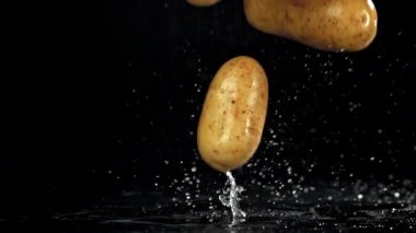 Taze patatesler masaya düşer. 1000 fps 'de yüksek hızlı bir kamerayla çekildi. Yüksek kaliteli FullHD görüntüler