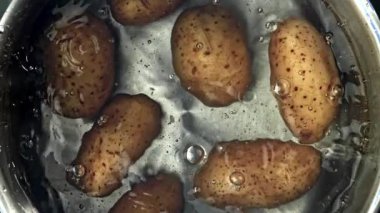Patatesler bir tencere suya düşer. Yukarıdan bak. 1000 fps 'de yüksek hızlı bir kamerayla çekildi. Yüksek kaliteli FullHD görüntüler
