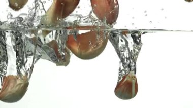 Sarımsak karanfilleri suyun altına düşer. 1000 fps 'de yüksek hızlı bir kamerayla çekildi. Yüksek kaliteli FullHD görüntüler