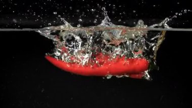 Kırmızı biber suyun altına düşer. 1000 fps 'de yüksek hızlı bir kamerayla çekildi. Yüksek kaliteli FullHD görüntüler