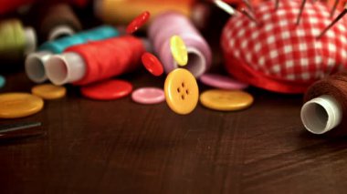 Dikiş düğmeleri ahşap bir masaya düşer. 1000 fps 'de yüksek hızlı bir kamerayla çekildi. Yüksek kaliteli FullHD görüntüler
