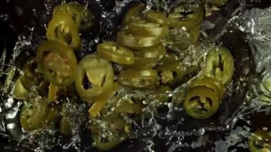 Terbiye edilmiş jalapenolar suya düşer. 1000 fps 'de yüksek hızlı bir kamerayla çekildi. Yüksek kaliteli FullHD görüntüler