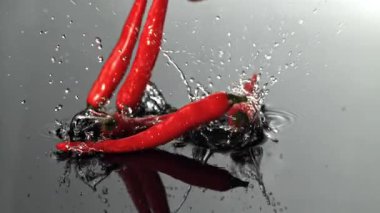 Şili biberleri ıslak bir yüzeye düşer. 1000 fps 'de yüksek hızlı bir kamerayla çekildi. Yüksek kaliteli FullHD görüntüler