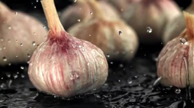 Su damlacıkları taze sarımsağın üzerine düşer. 1000 fps 'de yüksek hızlı bir kamerayla çekildi. Yüksek kaliteli FullHD görüntüler