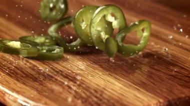 Terbiye edilmiş jalapenolar tahtaya düşer. 1000 fps 'de yüksek hızlı bir kamerayla çekildi. Yüksek kaliteli FullHD görüntüler