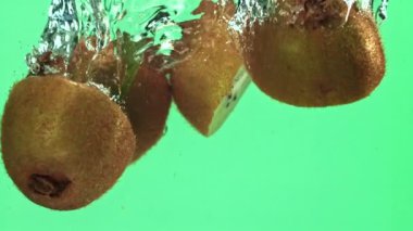 Dilimlenmiş kivi parçaları hafif arka planda suyun altına düşer. 1000 fps 'de yüksek hızlı bir kamerayla çekildi. Yüksek kaliteli FullHD görüntüler