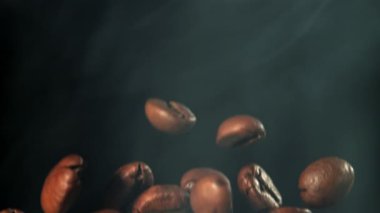 Süper yavaş çekimde dumanlı kahve çekirdekleri. 1000 fps 'de yüksek hızlı bir kamerayla çekildi. Yüksek kaliteli FullHD görüntüler