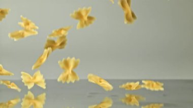 Süper yavaş çekimde kuru farfalle makarna. 1000 fps 'de yüksek hızlı bir kamerayla çekildi. Yüksek kaliteli FullHD görüntüler