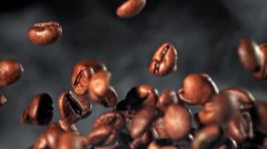 Süper yavaş çekimde dumanlı kahve çekirdekleri. 1000 fps 'de yüksek hızlı bir kamerayla çekildi. Yüksek kaliteli FullHD görüntüler