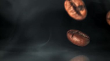 Süper yavaş çekimde dumanlı kahve çekirdekleri. 1000 fps 'de yüksek hızlı bir kamerayla çekildi. Yüksek kaliteli FullHD görüntüler