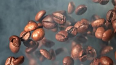 Süper yavaş çekimde dumanlı kahve çekirdekleri. 1000 fps 'de yüksek hızlı bir kamerayla çekildi. Yüksek kaliteli FullHD görüntüler