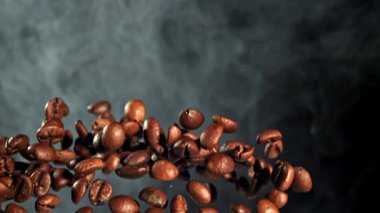 Süper yavaş çekimde dumanlı kahve çekirdekleri. 1000 fps 'de yüksek hızlı bir kamerayla çekildi. Yüksek kaliteli FullHD görüntüler