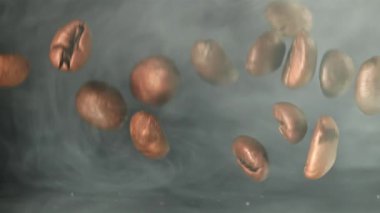 Süper yavaş çekimde dumanlı kahve çekirdekleri. 1000 fps 'de yüksek hızlı bir kamerayla çekildi. Yüksek kaliteli FullHD görüntüler