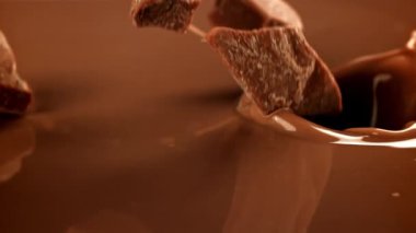 Süper yavaş çekimde siyah çikolata parçaları sıvı çikolatanın içine düşer. 1000 fps 'de yüksek hızlı bir kamerayla çekildi. Yüksek kaliteli FullHD görüntüler
