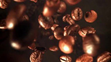 Süper yavaş çekimde kavrulmuş kahve çekirdekleri. 1000 fps 'de yüksek hızlı bir kamerayla çekildi. Yüksek kaliteli FullHD görüntüler