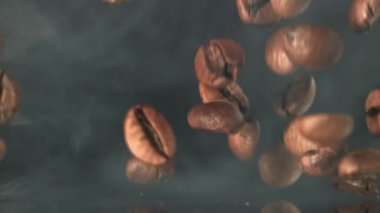 Süper yavaş çekimde dumanlı kahve çekirdekleri. 1000 fps 'de yüksek hızlı bir kamerayla çekildi. Yüksek kaliteli FullHD görüntüler